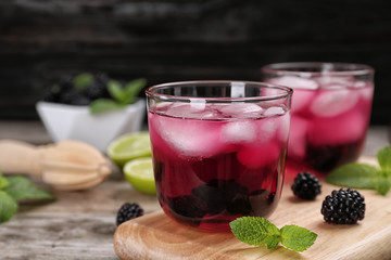 Glasses with iced blackberry lemonade on table