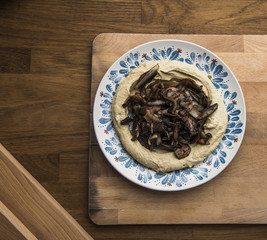 a plate of mushroom hummus, wooden background