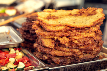 Pile of fried potato fritters at a fair.