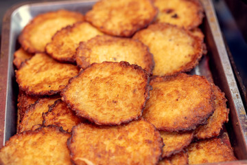 Pile of fried potato fritters at a fair.