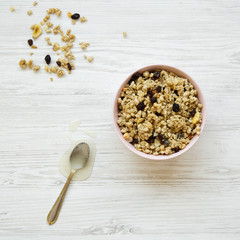 Pink bowl of fruit granola and honey, top view. Flat lay, overhead, from above.
