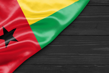 Flag of Guinea Bissau and place for text on a dark wooden background