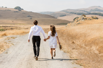 Love story. Couple holding hands and running away in mountains. Woman and man in love walking outdoors.