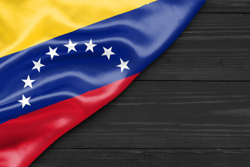 Flag of Venezuela and place for text on a dark wooden background