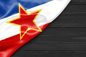 Flag of Yugoslavia and place for text on a dark wooden background