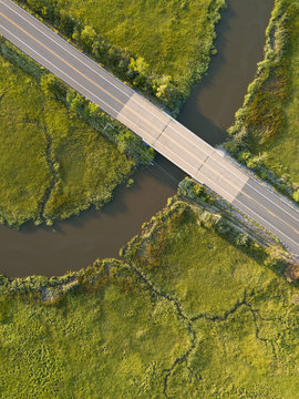 Local road crosses over the many twists and bends of the Maurice River and tributaries as seen from an aerial drone iage