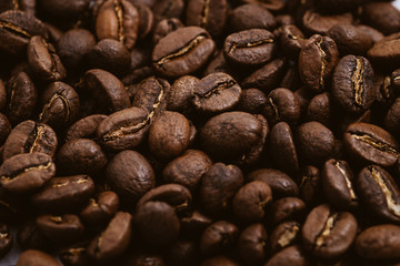 Coffee beans roasted on a wooden table with much of beans with a great aroma