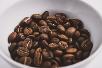 Coffee beans roasted on a wooden table with much of beans with a great aroma