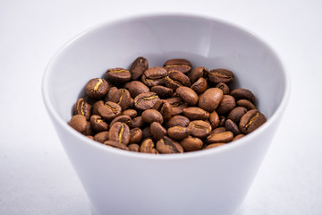 Cup of Coffee Beans roasted on a wooden table with fresh bean with great aroma