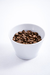 Cup of Coffee Beans roasted on a wooden table with fresh bean with great aroma