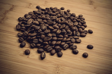 Coffee beans roasted on a wooden table with much of beans with a great aroma