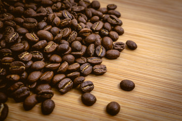 Coffee beans roasted on a wooden table with much of beans with a great aroma