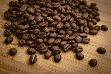 Coffee beans roasted on a wooden table with much of beans with a great aroma