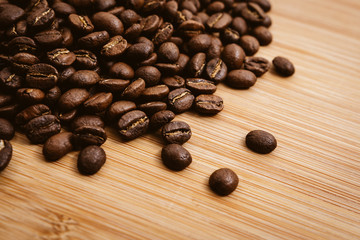 Coffee beans roasted on a wooden table with much of beans with a great aroma