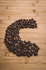 Coffee beans roasted on a wooden table with much of beans with a great aroma