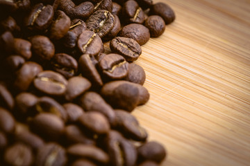 Coffee beans roasted on a wooden table with much of beans with a great aroma