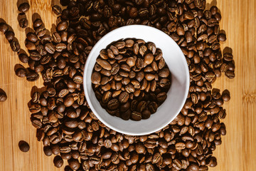 Cup of Coffee Beans roasted on a wooden table with fresh bean with great aroma