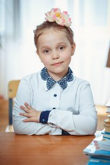 A schoolgirl sits at a desk