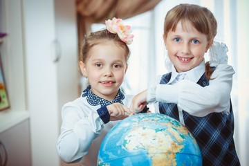 Two schoolgirls with a globe