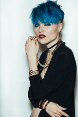 fashion photography of a girl with blue hair on a white background looking directly at the camera....