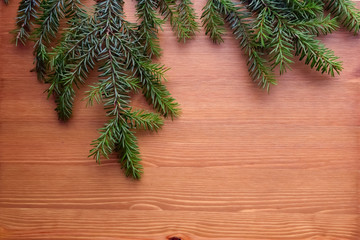 Christmas and New Year's composition. Branches of spruce with a wood background. The concept for a poster, greeting card. A place to paste text.