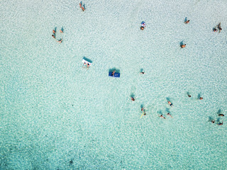 Aerial view of relaxed people swimming on a clear  and transparent sea. Cala Brandinchi, Sardinia, Italy.