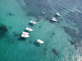 Aerial view of some inflatable boat floating on a beautiful turquoise sea. Sardinia, Italy.
