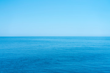 Sea and the cloudless blue sky, flowing into the horizon