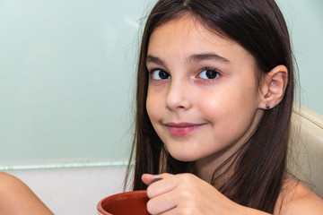 background. beautiful girl eats sitting at the table