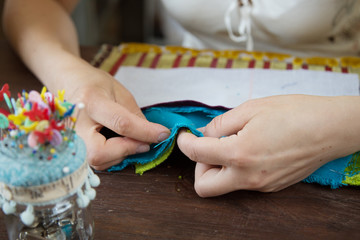 A female tailor stitching velvet pieces for a victorian chair reupholstery, home based business
