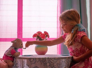 Little Girl Feeding Toy Lamb at Tea Party