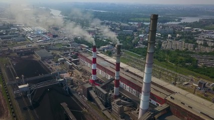 Aerial drone shot of the factory with pipes throwing out smoke