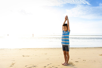 Fototapeta na wymiar Boy do Yoga on the beach
