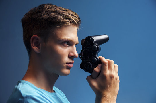 Side View Handsome Teen Holding Video Game Controller Like A Gun - Teen Gamer 