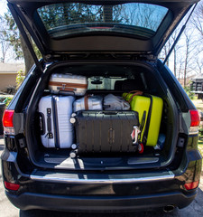 loading suitcase in car trunk