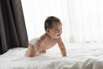 Asian new born baby in white sunny bedroom