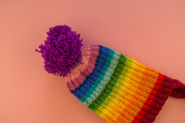 Rainbow cap made of wool on a pink background