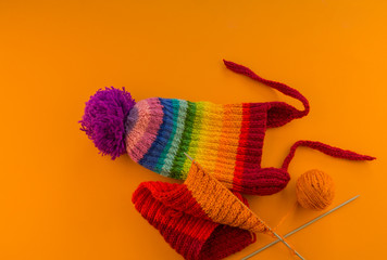 Rainbow cap made of wool on an orange background