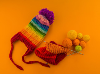Rainbow cap made of wool on an orange background