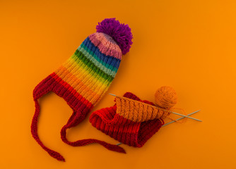 Rainbow cap made of wool on an orange background
