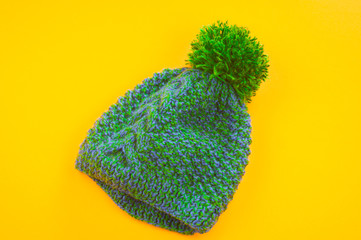 Green-blue cap of wool on a yellow background