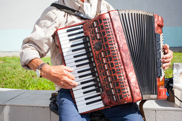 elderly man playing the accordion outdoors - obrazy, fototapety, plakaty