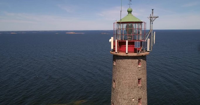 Lighthouse, C4K aerial drone view away from a tall lighthouse on a rocky island bengtskar, on a sunny summer day, in saaristomeri national park, Varsinais-suomi, Finland