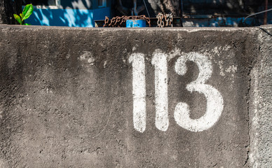 113 number on a stree wall paint in white