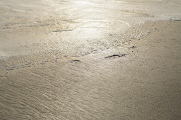 Rough wet sand surface in sunlight