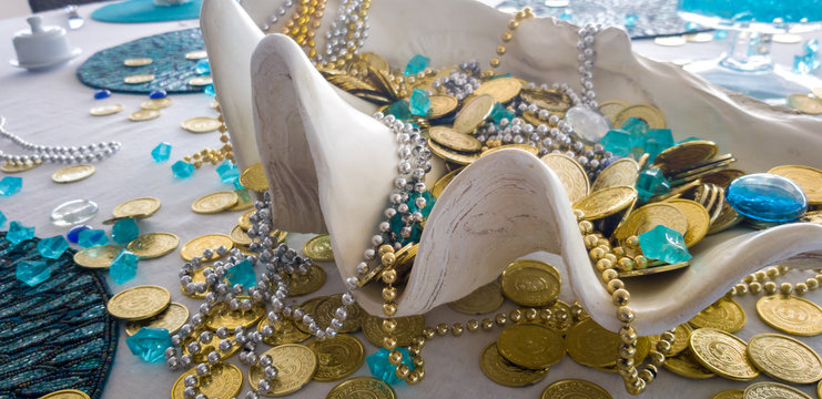 Table deocoration with a giant clam shell and a pirate treasure of fake coins and collars