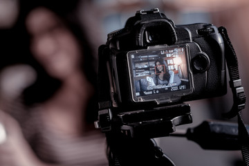 New technologies. Dark-haired smiling blogger talking while making a video for her blog
