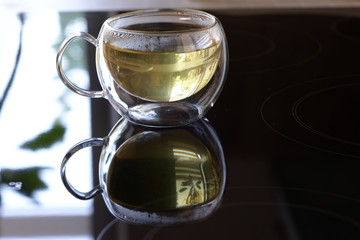 Cup of tea reflecting in the black mirror