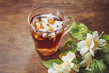 jasmine flowers and tea on a wooden background.