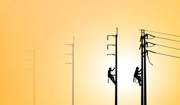 Silhouette Electrical Engineers Working On Electricity Pylon High Tension Power Line Repairs And Maintenance  On Blurry Sunset Background